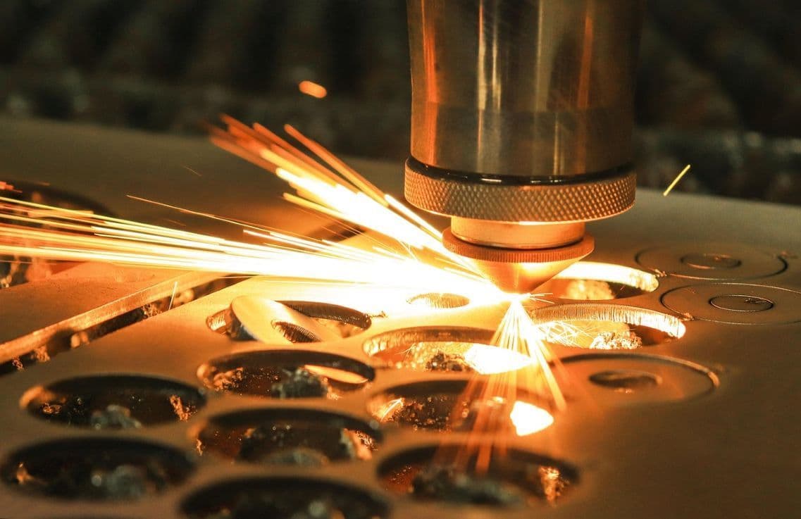 Cabezal de corte láser trabajando sobre lámina metálica